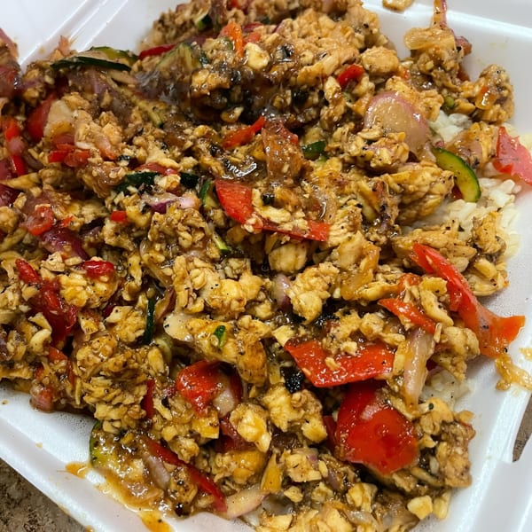 Close-up of a WRAP-A-LOT Fresh Express salad with chicken, red peppers, and zucchini in a white container.